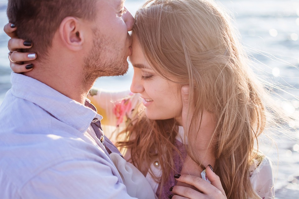Muž dává polibek ženě na čelo